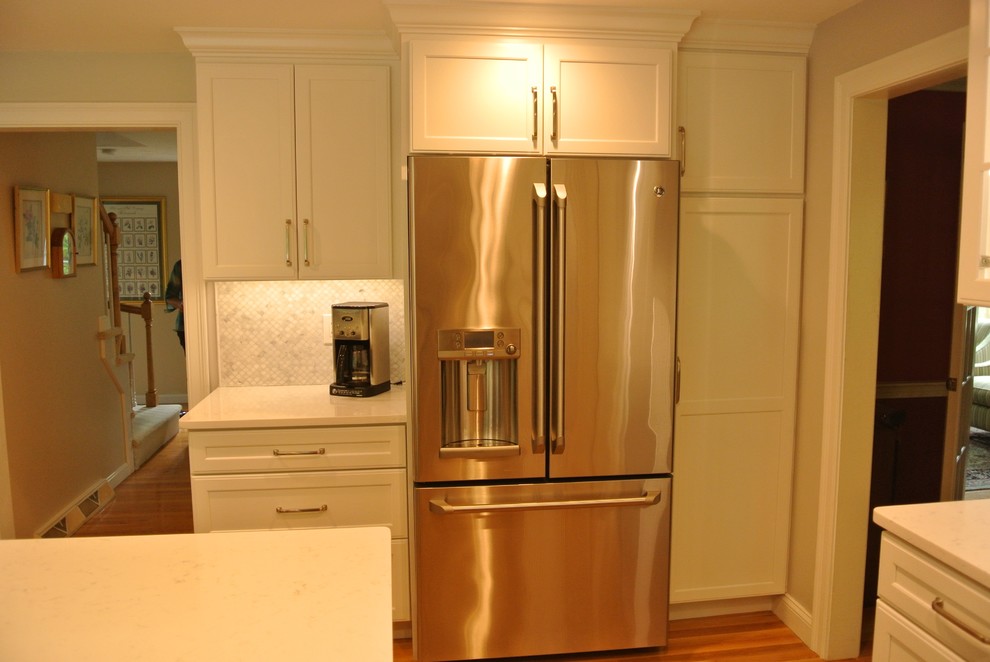 Example of a transitional medium tone wood floor eat-in kitchen design in Boston with an undermount sink, shaker cabinets, quartz countertops, beige backsplash, mosaic tile backsplash, stainless steel appliances, an island and white countertops