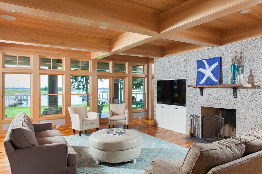 This is an example of a mid-sized beach style open concept living room in Other with grey walls, light hardwood floors, a standard fireplace, a concrete fireplace surround, a built-in media wall and orange floor.
