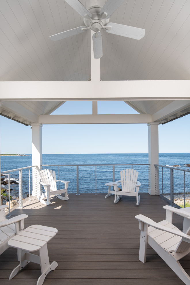 Photo of a medium sized nautical back wire cable railing veranda in Boston with with columns and a roof extension.
