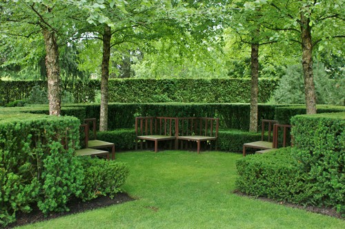 These interesting benches are integrated with the shapes of the hedges around this outdoor area. Incorporating the benches with the landscape is a wonderful way to make your area feel very intentional and planned.