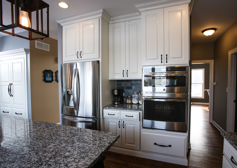 Eat-in kitchen - large transitional u-shaped dark wood floor eat-in kitchen idea in Chicago with white cabinets, gray backsplash, stainless steel appliances and an island