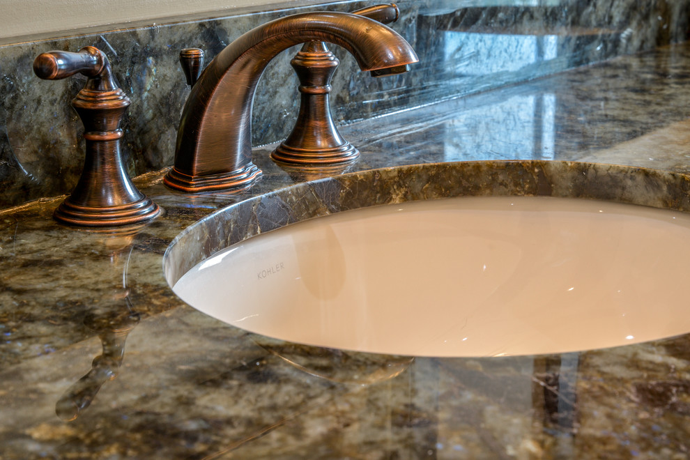 Example of a mid-sized mountain style master beige tile and travertine tile ceramic tile and beige floor alcove bathtub design with recessed-panel cabinets, dark wood cabinets, beige walls, an undermount sink, granite countertops and brown countertops