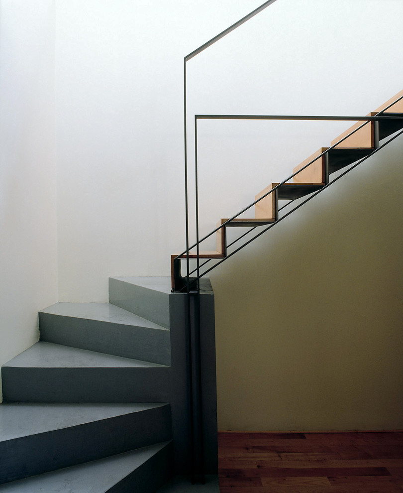 Small contemporary wood curved staircase in Turin with wood risers and metal railing.