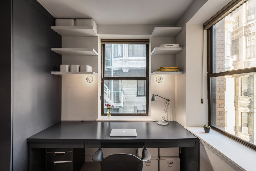 Inspiration for a small modern built-in desk study room remodel in New York with white walls