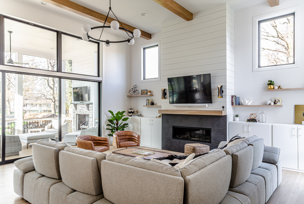 Design ideas for a large farmhouse open plan living room in DC Metro with white walls, light hardwood flooring, a ribbon fireplace, a tiled fireplace surround, a wall mounted tv, beige floors, exposed beams and tongue and groove walls.