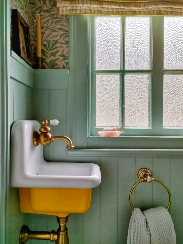 Esempio di un grande bagno di servizio american style con consolle stile comò, ante gialle, WC monopezzo, pavimento in marmo, lavabo sospeso e mobile bagno sospeso