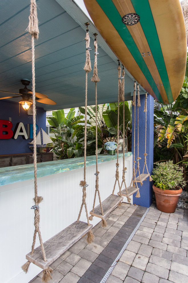 This is an example of a large beach style single-wall wet bar in Tampa with a drop-in sink, wood benchtops, brick floors, grey floor and blue benchtop.