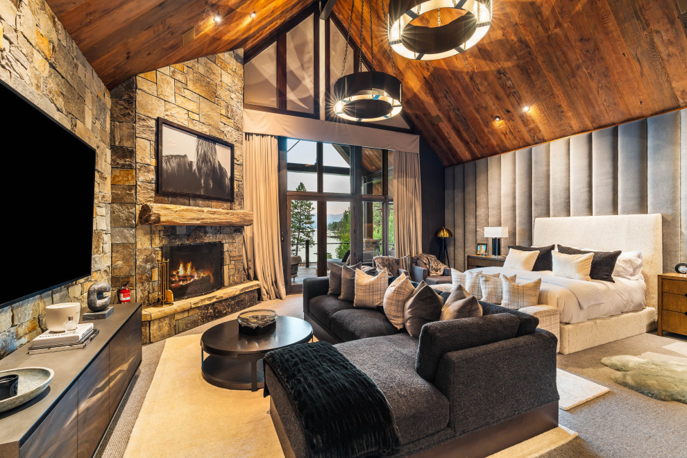 Inspiration for a rustic carpeted, gray floor, vaulted ceiling and wood ceiling bedroom remodel with gray walls, a corner fireplace and a stone fireplace