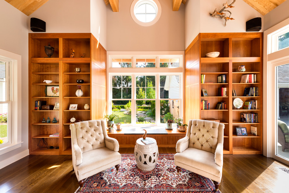 Inspiration for a traditional family room in Boston with a library, beige walls and dark hardwood floors.