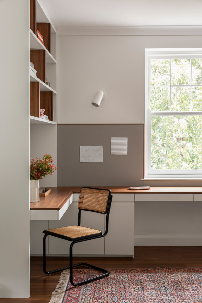 Idéer för att renovera ett funkis arbetsrum, med grå väggar, mörkt trägolv, ett inbyggt skrivbord och brunt golv