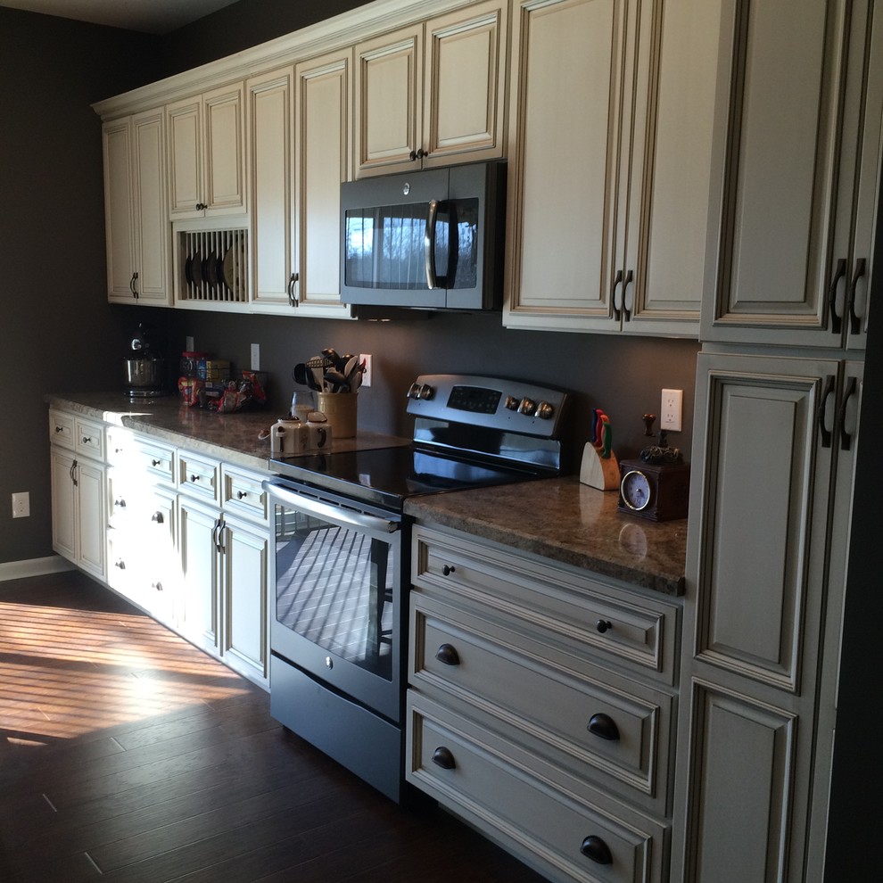 Example of a mid-sized transitional l-shaped dark wood floor and brown floor kitchen design in Cincinnati with raised-panel cabinets, beige cabinets, granite countertops and stainless steel appliances