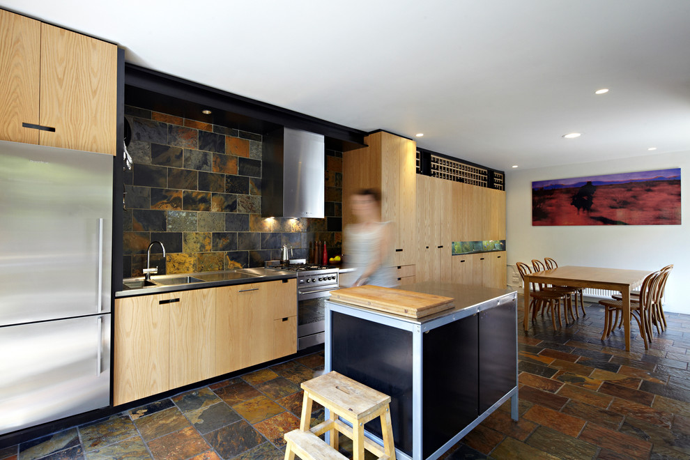 Inspiration for a small contemporary single-wall eat-in kitchen in Melbourne with an integrated sink, stainless steel benchtops, stone tile splashback, stainless steel appliances, slate floors and with island.