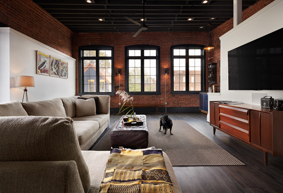 Inspiration for a large industrial open concept family room in Other with a home bar, vinyl floors, no fireplace, a wall-mounted tv, grey floor, exposed beam and brick walls.