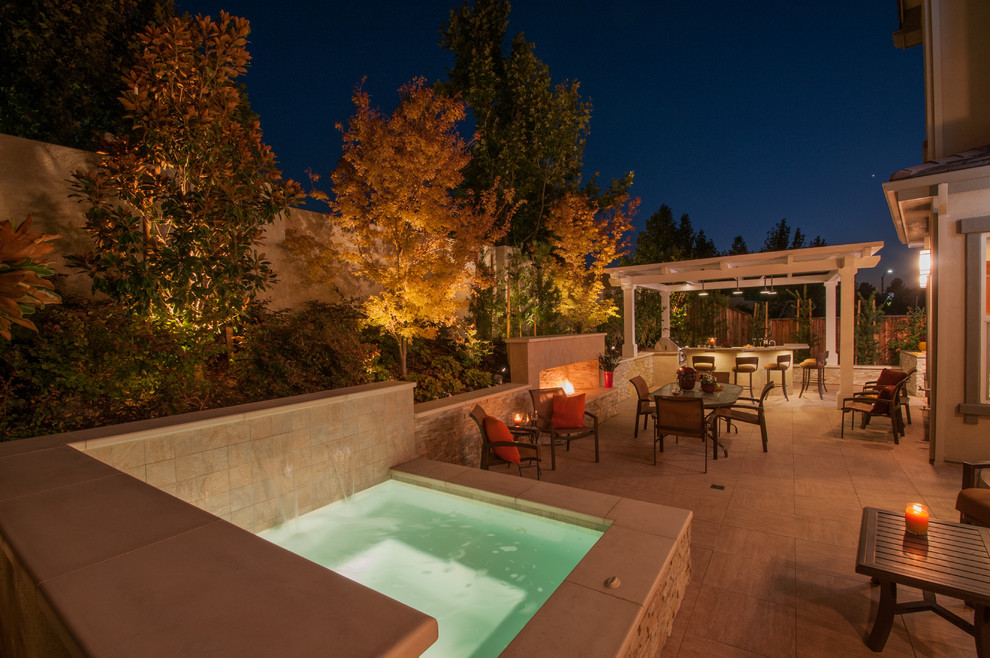Photo of a large contemporary backyard patio in San Francisco with an outdoor kitchen, tile and a pergola.