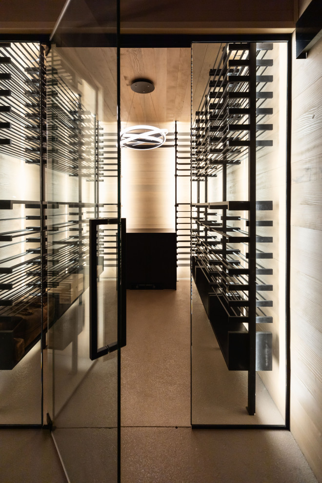 This is an example of a large contemporary wine cellar in Phoenix with concrete floors, storage racks and beige floor.