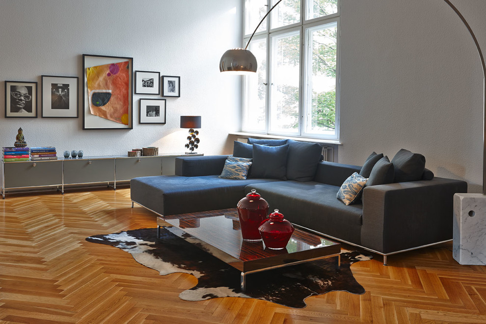 Large transitional formal enclosed living room in Berlin with white walls, light hardwood floors and no fireplace.