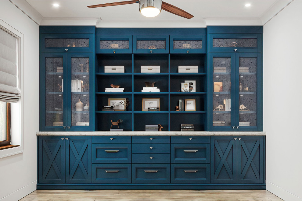 Inredning av ett lantligt mellanstort hemmabibliotek, med blå väggar, ljust trägolv, ett fristående skrivbord och beiget golv