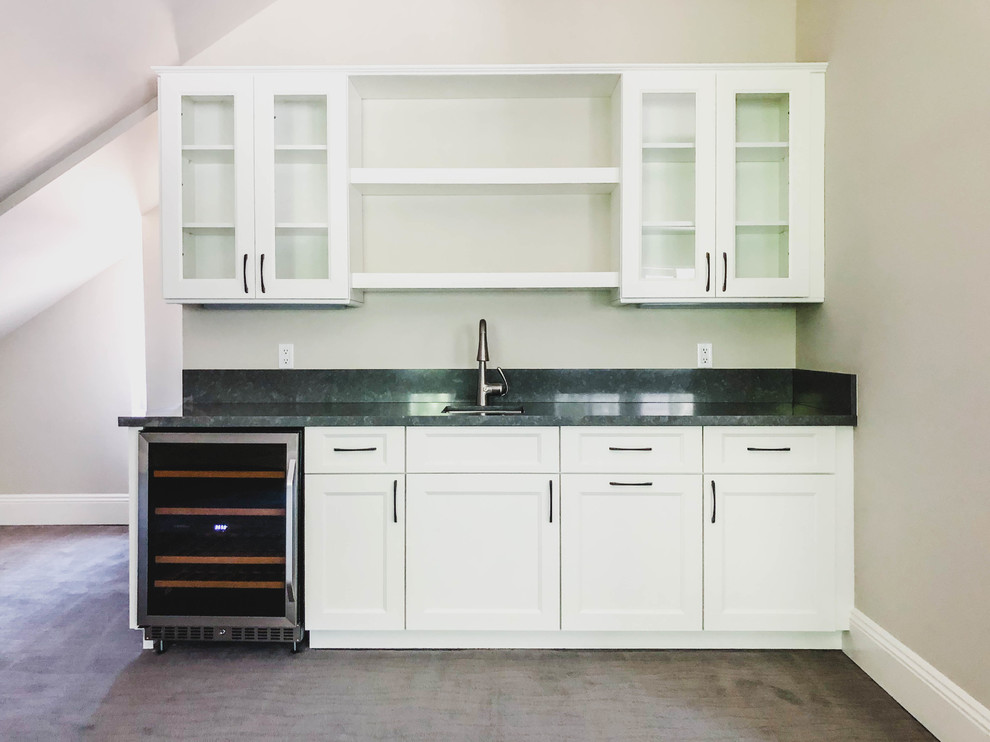 This is an example of a mid-sized contemporary single-wall kitchen pantry in Los Angeles with white cabinets, beige splashback, carpet, grey floor, grey benchtop, a drop-in sink, recessed-panel cabinets, quartz benchtops, granite splashback, stainless steel appliances and vaulted.