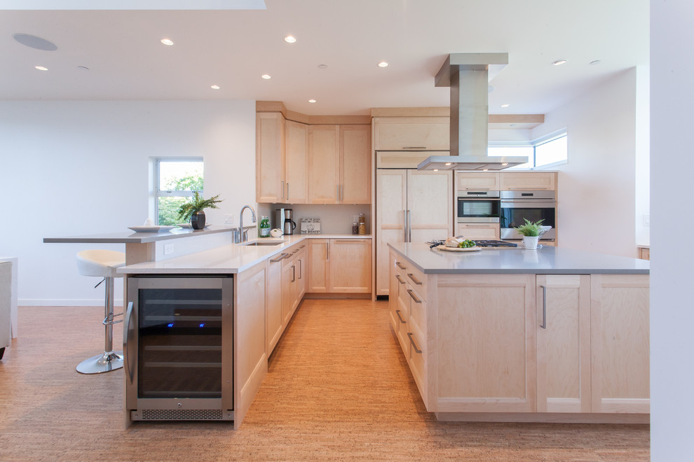 Photo of a contemporary u-shaped open plan kitchen in Vancouver with an undermount sink, shaker cabinets, light wood cabinets, quartz benchtops, white splashback, stone tile splashback, panelled appliances, cork floors and with island.