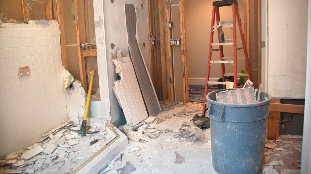 A bathroom mid-renovation with tools and materials scattered, illustrating the mess and risks of DIY remodeling.