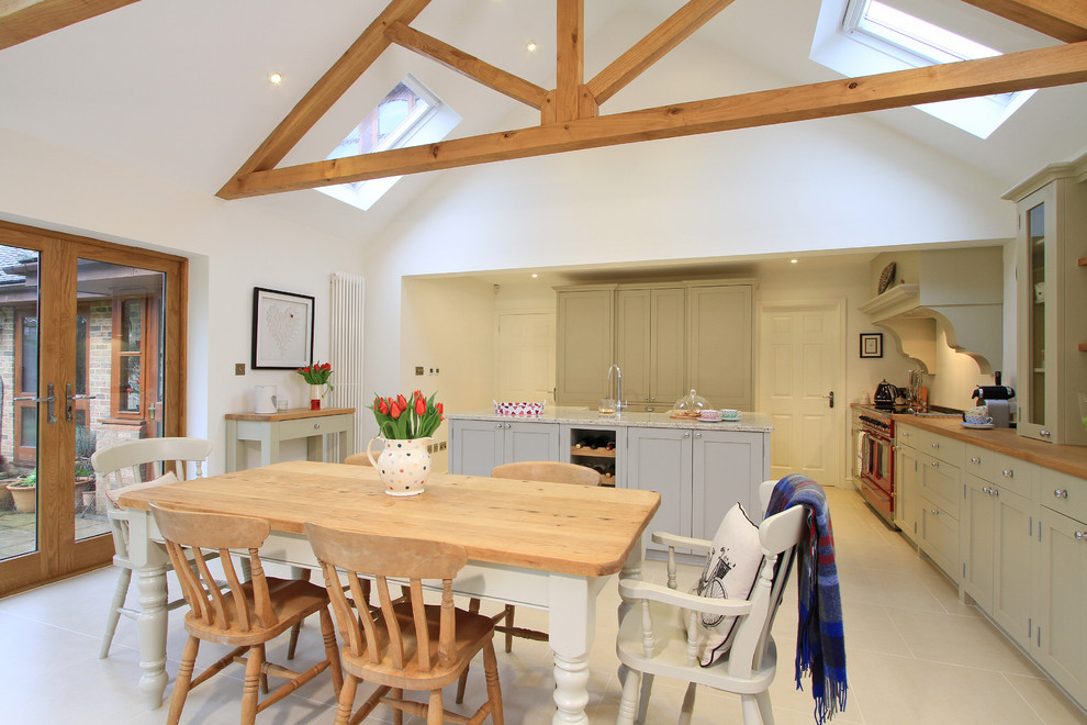 This is an example of a large traditional eat-in kitchen in Hampshire with a farmhouse sink, shaker cabinets, grey cabinets, granite benchtops, ceramic splashback, coloured appliances, porcelain floors and with island.