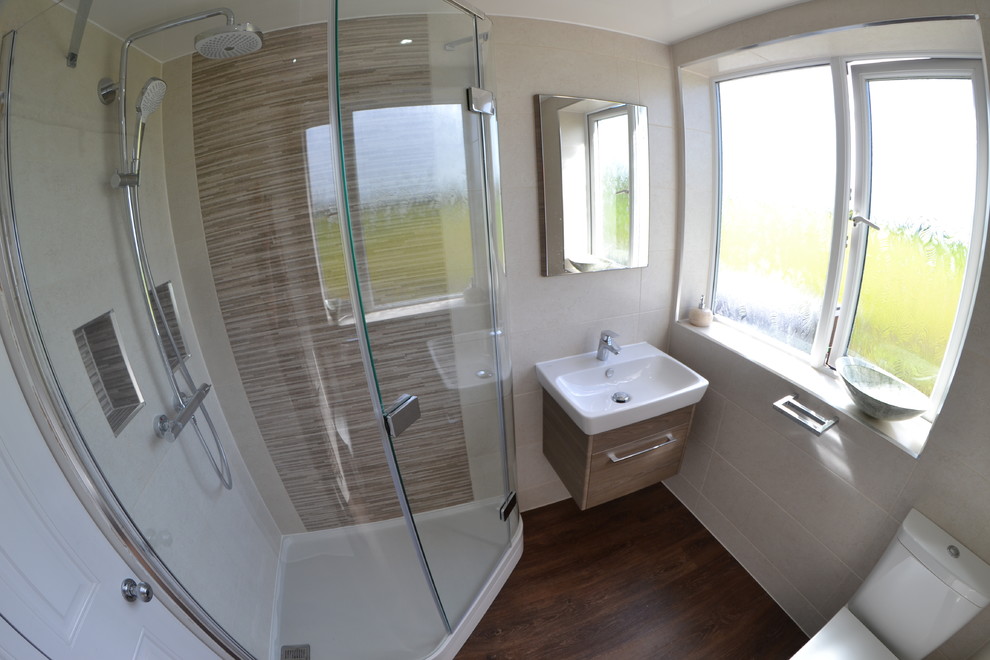 Photo of a small contemporary kids bathroom in Cheshire with medium wood cabinets, a corner shower, a two-piece toilet, multi-coloured tile, ceramic tile, multi-coloured walls, vinyl floors, a wall-mount sink, brown floor and a hinged shower door.