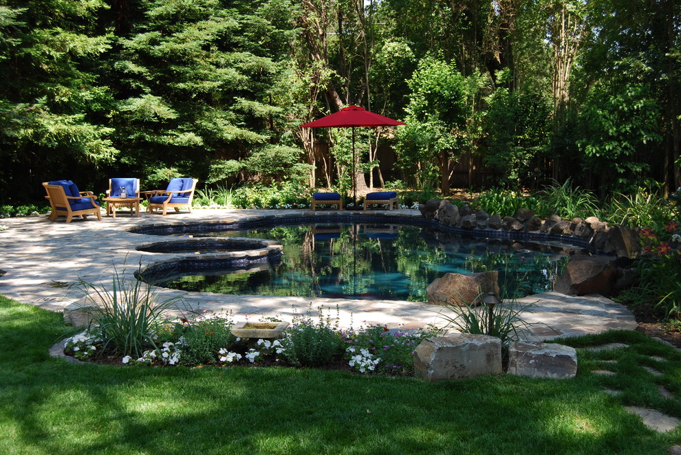 Inspiration for a traditional custom-shaped pool in San Francisco with natural stone pavers.