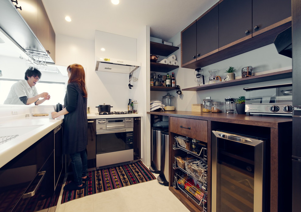 Traditional u-shaped kitchen in Nagoya with an integrated sink, flat-panel cabinets, brown cabinets, white splashback and stainless steel appliances.