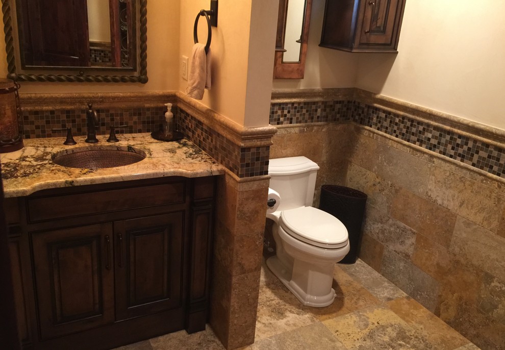Small country bathroom in Austin with an undermount sink, raised-panel cabinets, medium wood cabinets, granite benchtops, beige tile, stone tile, beige walls and travertine floors.