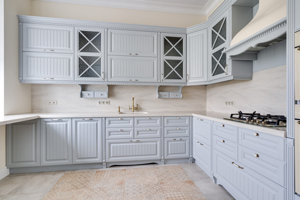Photo of a mid-sized country l-shaped eat-in kitchen in Moscow with an integrated sink, raised-panel cabinets, grey cabinets, solid surface benchtops, beige splashback, marble splashback, porcelain floors, beige floor and beige benchtop.