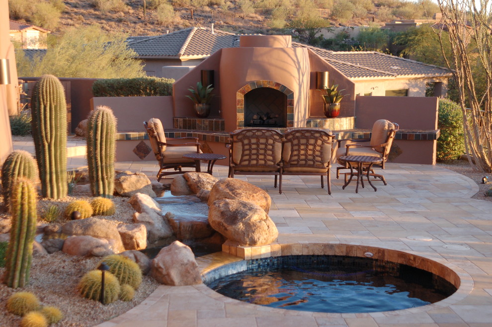 Large backyard patio in Phoenix with a fire feature, concrete pavers and no cover.