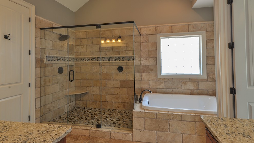 Mid-sized mediterranean master bathroom in Atlanta with medium wood cabinets, beige walls, granite benchtops, a drop-in tub, a corner shower, beige tile, travertine, travertine floors, beige floor and a hinged shower door.