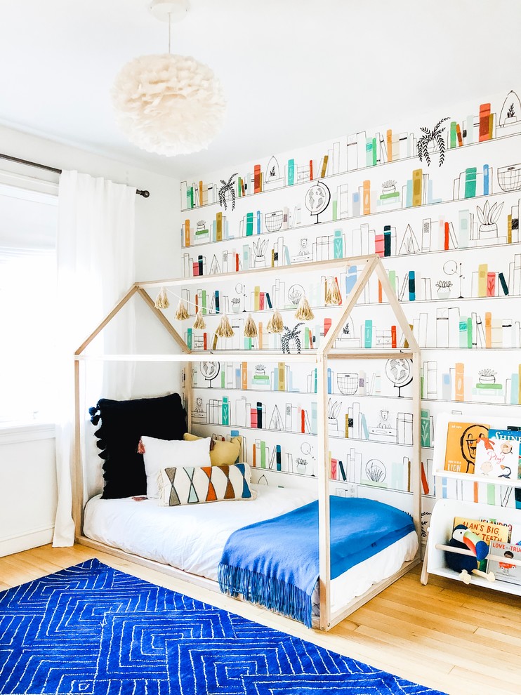 Inspiration for a small scandinavian gender-neutral kids' bedroom for kids 4-10 years old in New York with multi-coloured walls, light hardwood floors and brown floor.