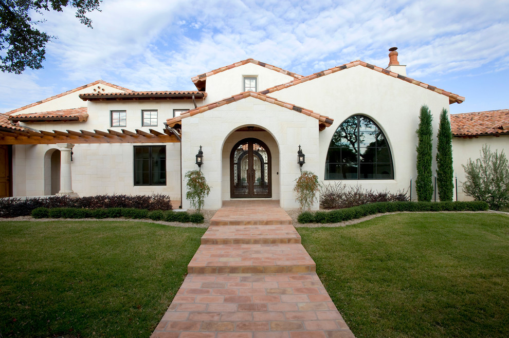 Design ideas for a mediterranean two-storey stucco exterior in Austin with a tile roof.