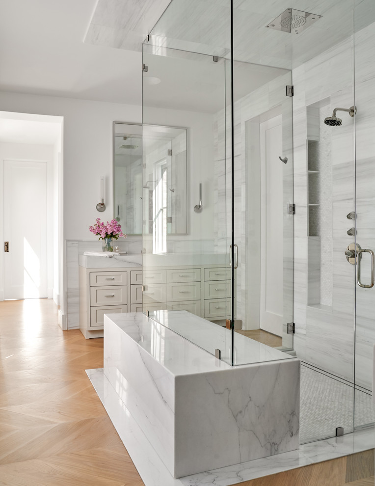 Beverly | 2018 - Walk-in shower - mid-sized transitional master gray tile, white tile and porcelain tile light wood floor and brown floor walk-in shower idea in Dallas with shaker cabinets, beige cabinets, white walls, a hinged shower door, white countertops and marble countertops