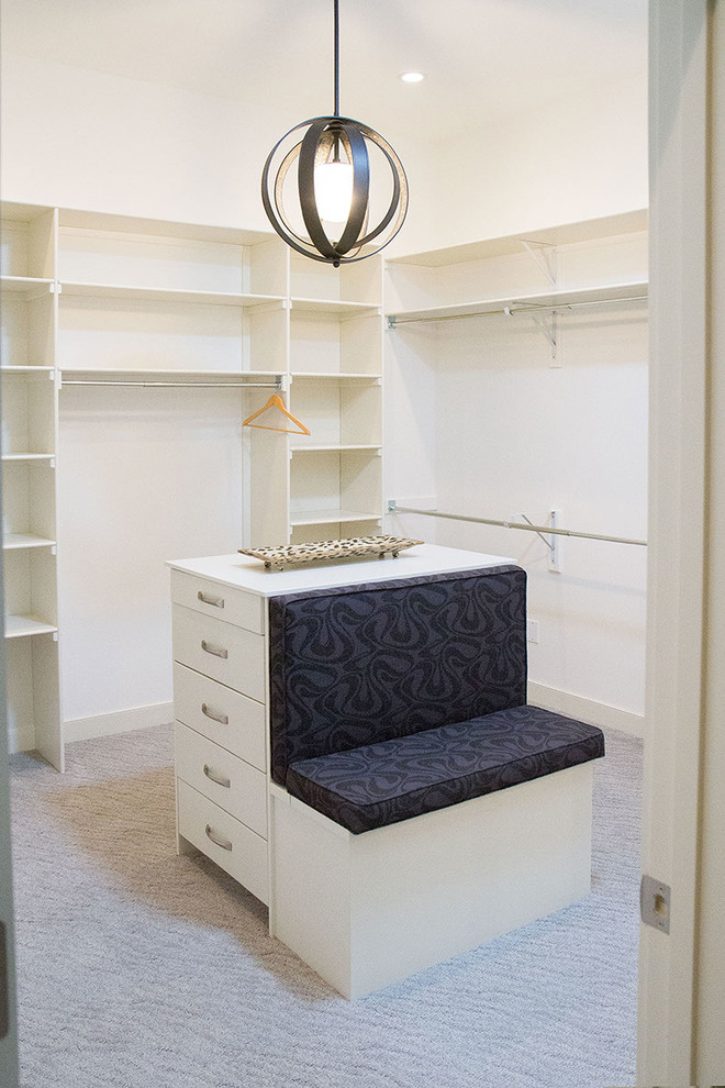 Design ideas for a mid-sized contemporary gender-neutral dressing room in Calgary with flat-panel cabinets, white cabinets and carpet.