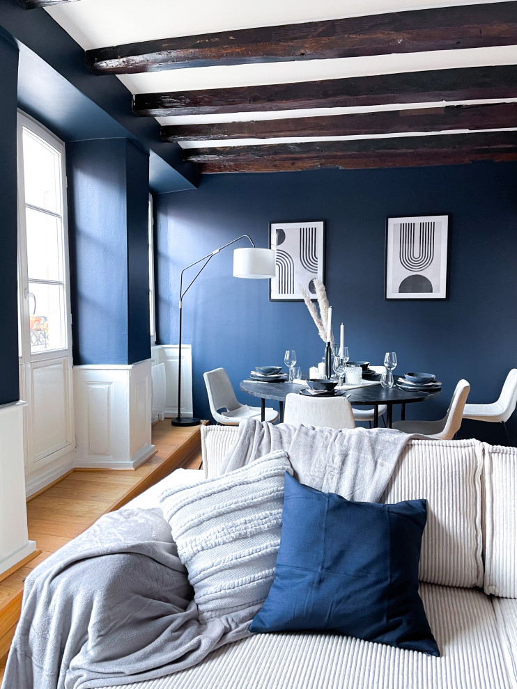 Idée de décoration pour une salle de séjour tradition de taille moyenne et ouverte avec un mur bleu, parquet clair, aucune cheminée, un téléviseur indépendant, un sol jaune, poutres apparentes et éclairage.