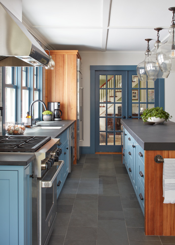 Inspiration for a mid-sized country single-wall eat-in kitchen in Boston with a single-bowl sink, recessed-panel cabinets, blue cabinets, limestone benchtops, blue splashback, subway tile splashback, stainless steel appliances, slate floors, with island and grey floor.