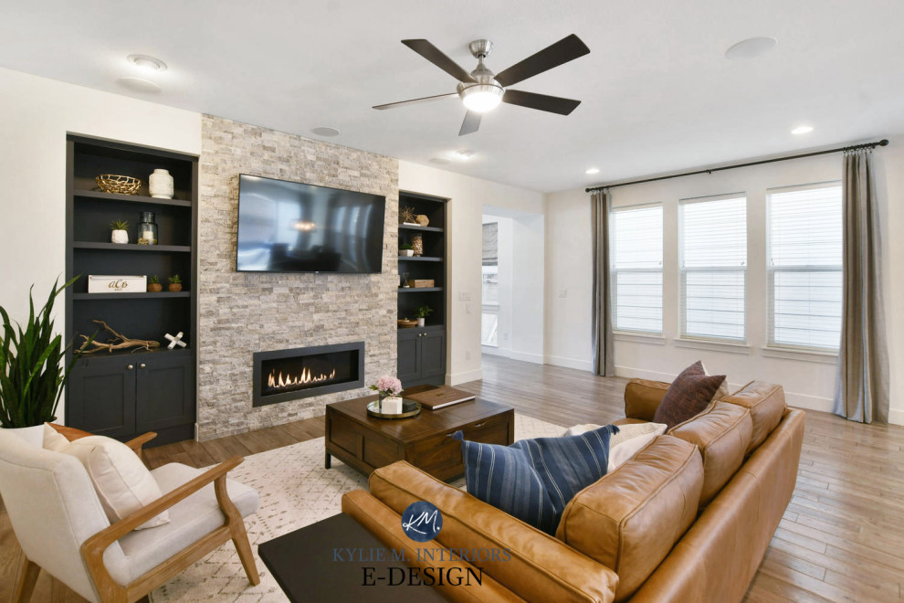 This is an example of a mid-sized transitional open concept living room with white walls, porcelain floors, a standard fireplace, a wall-mounted tv and beige floor.