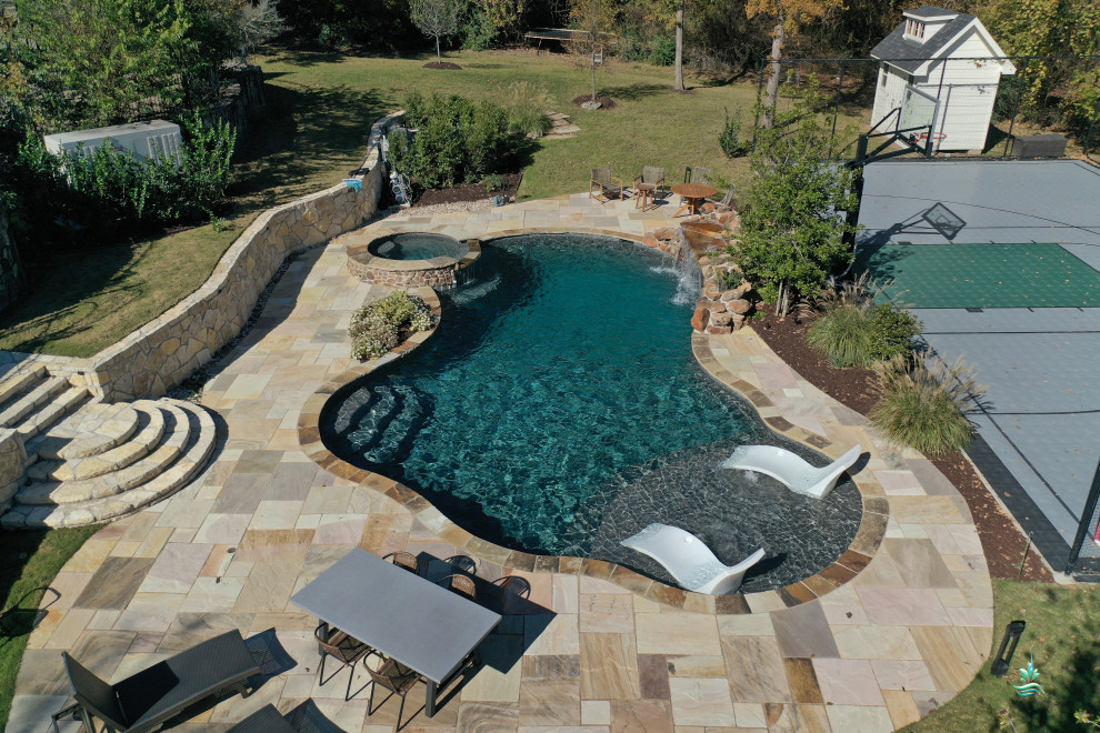 Diseño de piscina natural rústica extra grande a medida en patio trasero con privacidad y adoquines de piedra natural