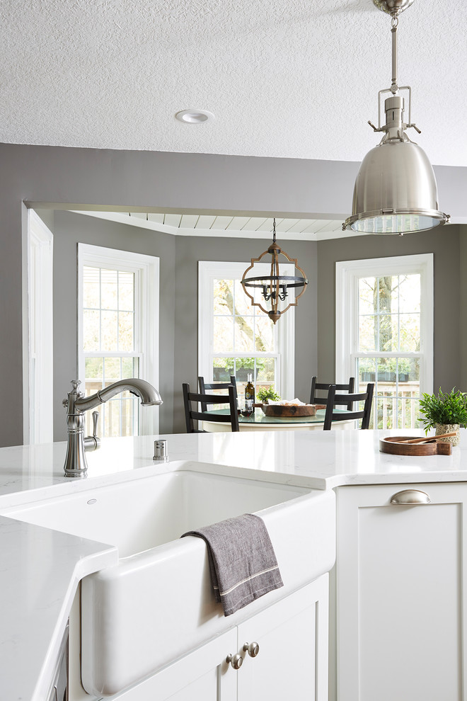 Inspiration for a large country u-shaped open plan kitchen in Minneapolis with a farmhouse sink, white cabinets, quartzite benchtops, white splashback, subway tile splashback, stainless steel appliances, with island, brown floor, shaker cabinets and dark hardwood floors.