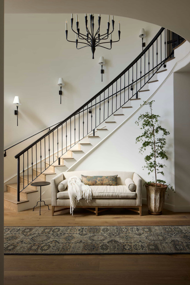 Inspiration for a large mediterranean wooden curved metal railing staircase remodel in Los Angeles with wooden risers