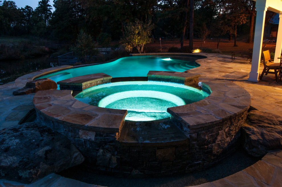 Design ideas for a mid-sized country backyard round pool in Other with a hot tub and natural stone pavers.