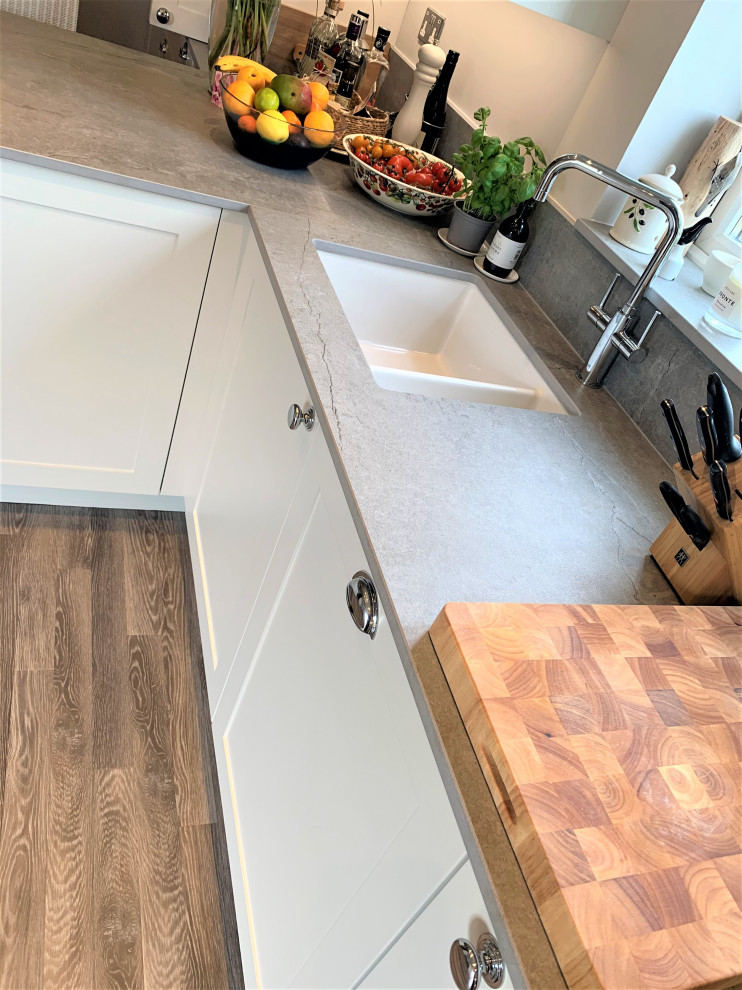Inspiration for a small traditional single-wall kitchen/diner in Other with a belfast sink, shaker cabinets, medium wood cabinets, engineered stone countertops, vinyl flooring, grey floors, grey worktops and a feature wall.