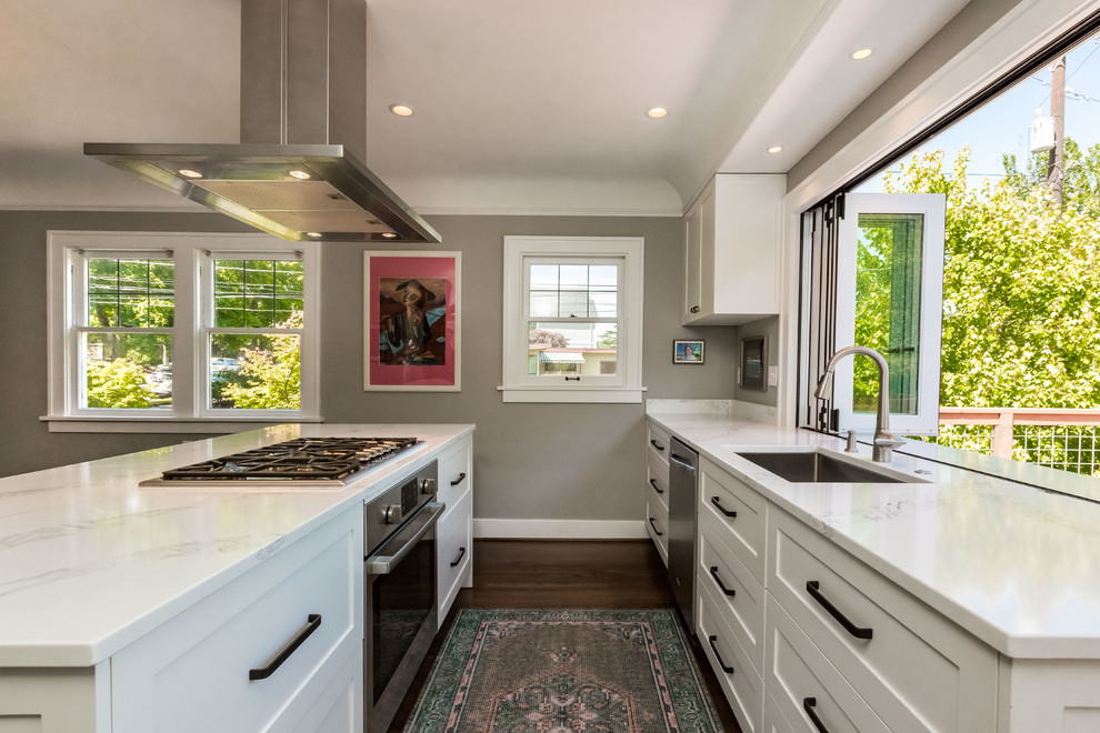 Open concept kitchen - mid-sized transitional l-shaped dark wood floor and brown floor open concept kitchen idea in Seattle with an undermount sink, shaker cabinets, white cabinets, quartz countertops, white backsplash, porcelain backsplash, stainless steel appliances and an island