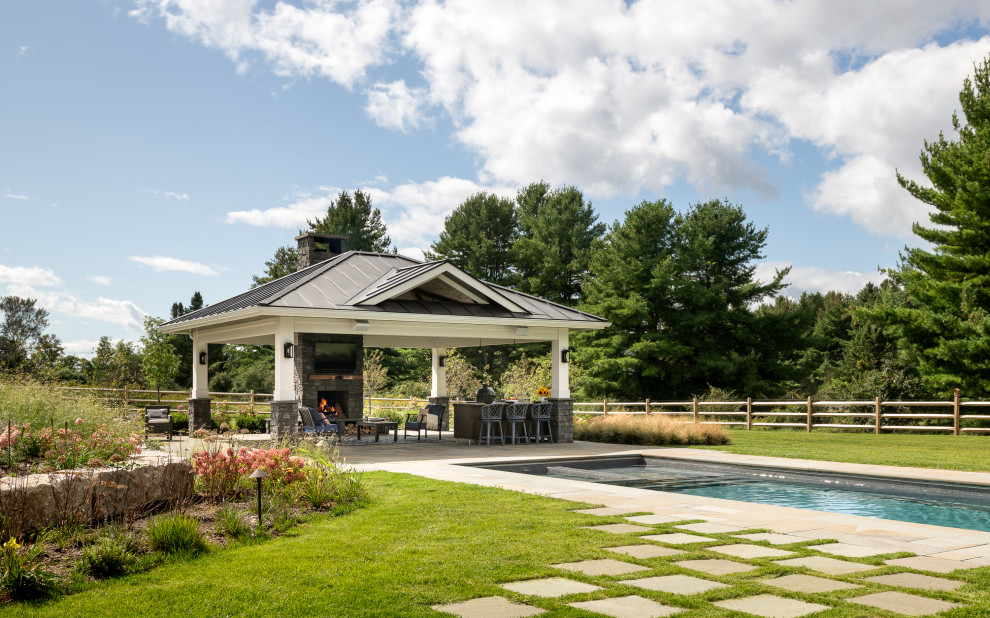 Large transitional backyard patio in Burlington with an outdoor kitchen, natural stone pavers and a gazebo/cabana.