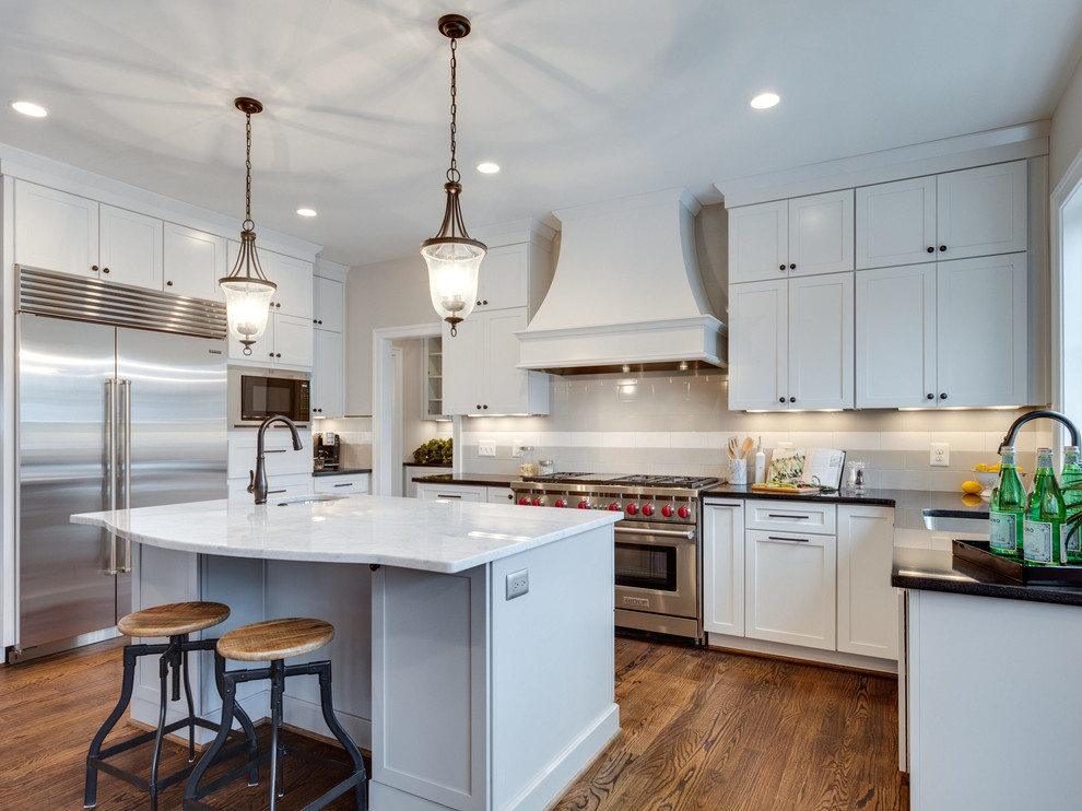 Photo of a transitional kitchen in DC Metro with an undermount sink, shaker cabinets, white cabinets, grey splashback, stainless steel appliances, medium hardwood floors and with island.