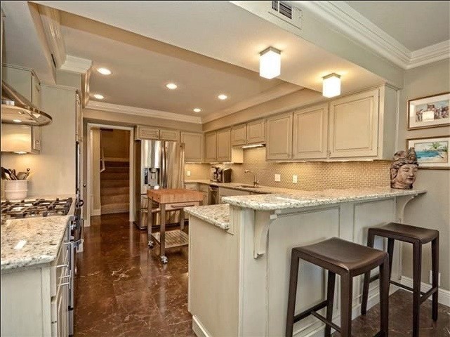 Mid-sized transitional marble floor enclosed kitchen photo in Austin with a single-bowl sink, raised-panel cabinets, gray cabinets, granite countertops, gray backsplash, glass tile backsplash, stainless steel appliances and an island