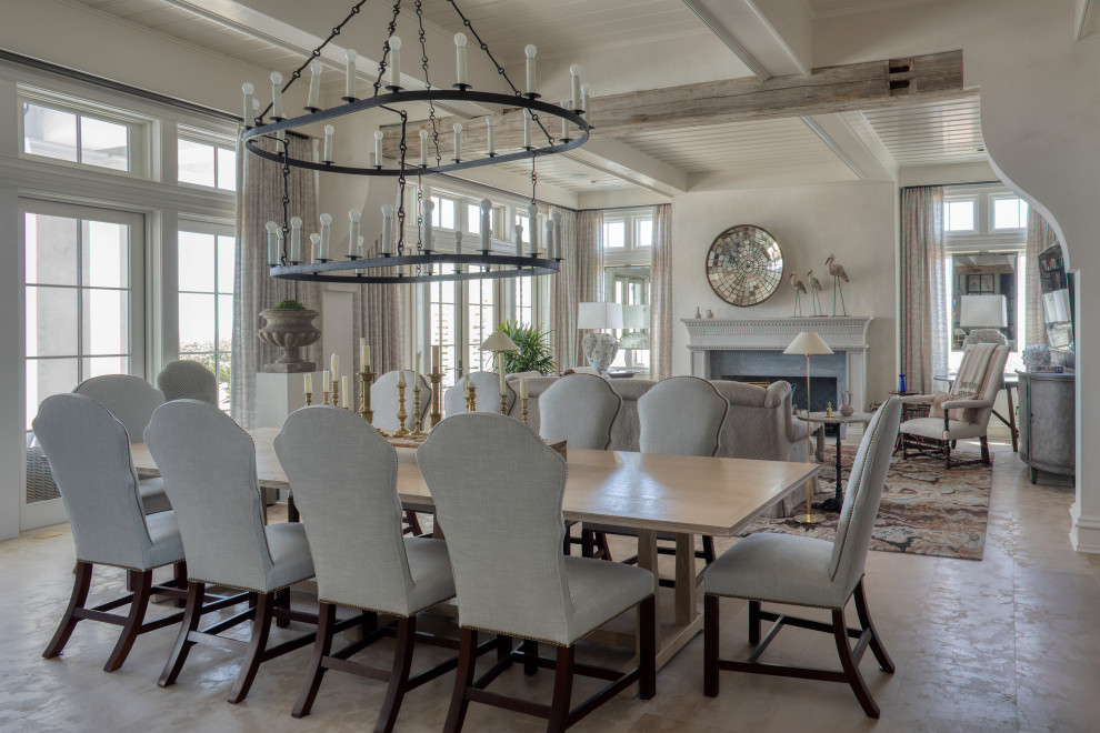 Photo of an expansive coastal dining room in Other with white walls, concrete flooring, a standard fireplace, a concrete fireplace surround, beige floors and a coffered ceiling.