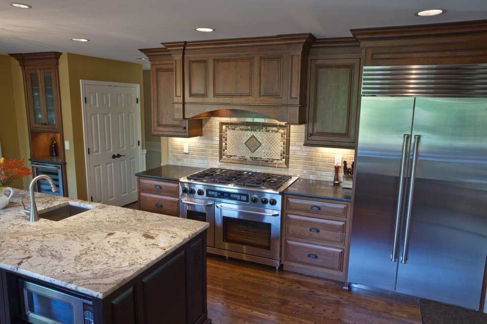 This is an example of a traditional galley eat-in kitchen in Seattle with an undermount sink, recessed-panel cabinets, medium wood cabinets, granite benchtops, beige splashback and stainless steel appliances.